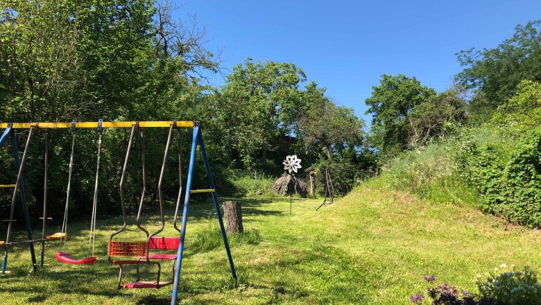 Spielplatz mit Schaukeln in grüner, bewaldeter Umgebung., © Donau Niederösterreich