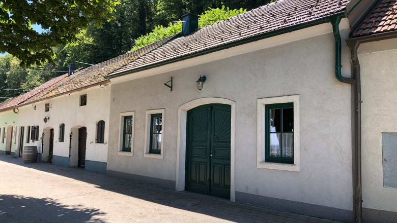 Traditionelles Gebäude mit grüner Tür und Fenstern, umgeben von Bäumen., © Donau Niederösterreich